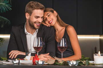 Excited loving couple celebrating special event with wine and candles , having dinner together. Love and relationship. celebrating special event, anniversary Valentine`s day