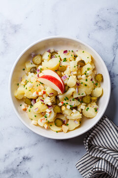 Traditional German potato salad with pickles, onions and apple.