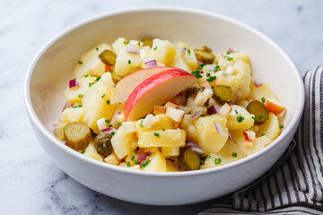 Traditional German potato salad with pickles, onions and apple.
