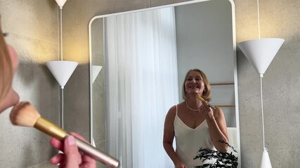 A cheerful woman oyfully enjoys her skincare routine in her tranquil, plantfilled bathroom