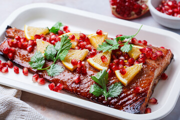 Christmas salmon in pomegranate juice with orange and pomegranate seeds.