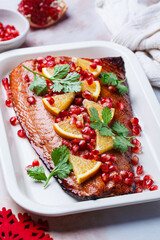 Christmas salmon in pomegranate juice with orange and pomegranate seeds.