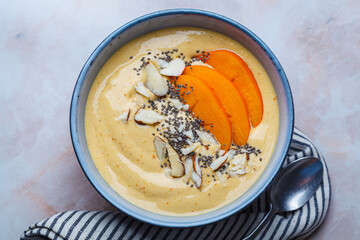 Persimmon smoothie bowl with chia seeds and nuts.