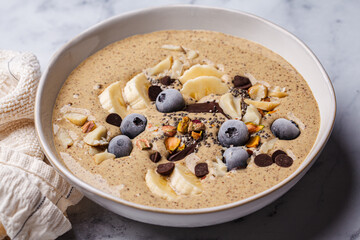 Chocolate smoothie bowl with banana, blueberries and nuts.