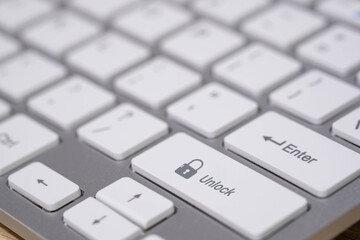 A close-up keyboard with an unlock key and open padlock icon represents access control, cybersecurity, data protection, login permission, and secure system management in the digital environment.