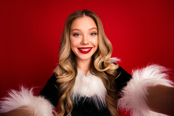 Delighted woman in festive fur trim smiles for a warm christmas portrait against a vivid red background