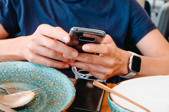 a man checks a charging phone at the table