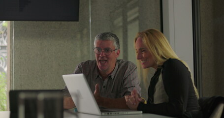 Colleagues smile and clasp hands in moment of friendly support during office meeting, celebrating teamwork and shared success