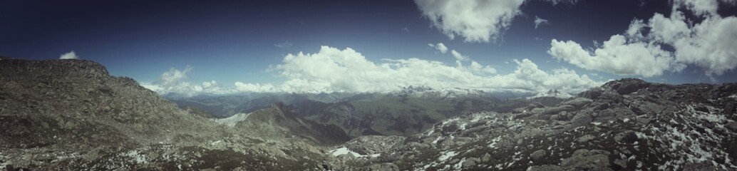 Obraz premium Wide panorama of a scenic mountainous landscape under a partly cloudy sky