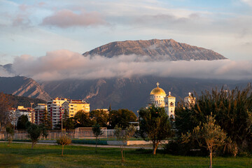 Mountain sunset landscape with city buildings and an Orthodox church 
