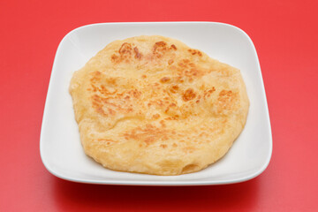 Chapati – pain traditionnel indien et sri-lankais. Fond rouge. 