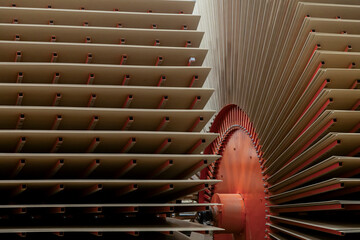 Large stacks of wood panels or MDF sheets arranged inside an industrial production facility. The image shows part of the machinery used to process and dry wood panels.