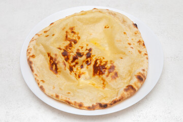 Naan au fromage sur fond blanc – pain indien traditionnel