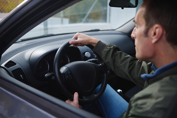 Confident Man Driving Car Inside View: Steering Wheel Grip, Focused Look, Road Ahead, Calm Moment