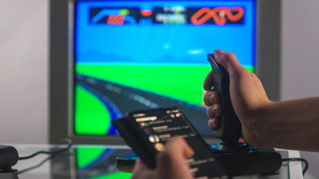 Playing an old school 8-bit game running on a CRT TV. Texting on a modern mobile phone - Powered by Adobe