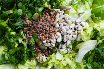 Top view macro of green leaves, parsley, dill and assorted seeds for clean eating recipes, healthy raw ingredients and plant-based cooking background, close-up