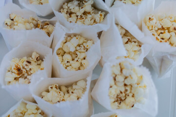 Several paper cones filled with popcorn arranged together. The image shows a snack setup suitable for parties, events, or food service.