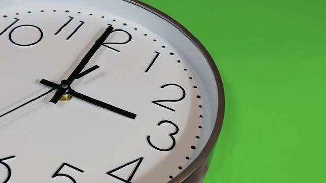 Time change in autumn and spring, close-up at 3 o'clock. Copy space with green background.