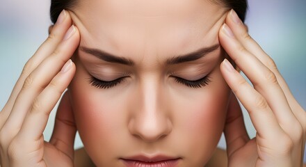 Fototapeta premium Stressed young woman with a tension headache touching her temples in pain.