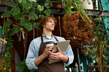 Creative young man enjoying coffee while working in a bright, artistic café environment