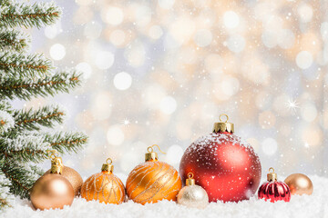 Festive christmas ornaments and snowy tree with bokeh lights
