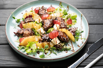 chicken liver salad with caramelized pear and balsamic sauce on plate.