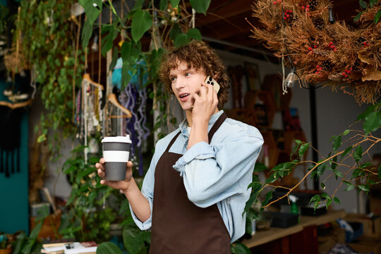 Creative young man enjoying a lively conversation while holding a coffee cup in a lush setting