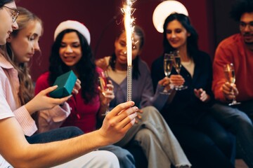 Friends celebrating holiday party, enjoying champagne, and opening gifts