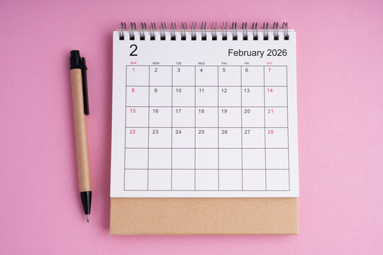 February 2026 desk calendar with eco friendly pen on a pink background, representing planning, scheduling, and organization in a clean minimalist workspace