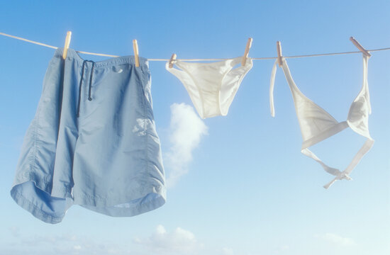 His and Hers bathing suits drying on clothesline