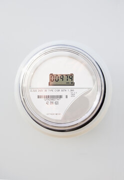 Close-up of digital electric meter on white wall