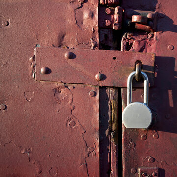 Close-up of padlock on brown metal door