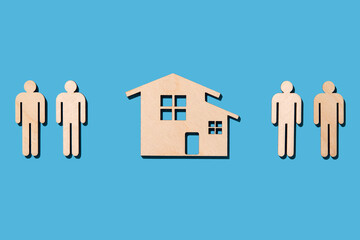 Wooden cutouts of people and home on blue background