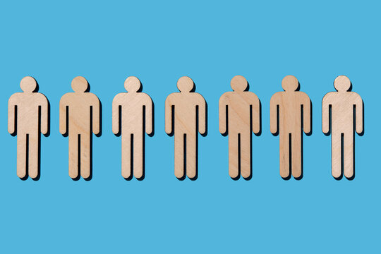 Line of wooden cutouts of people on blue background