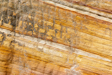 Close-up of textured sandstone showing diagonal bands of yellow