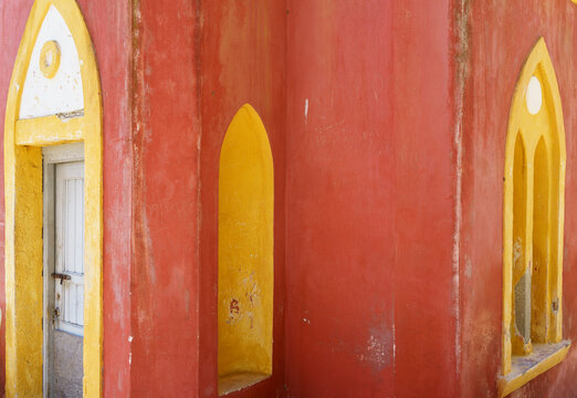 Brightly colored wall with pointed arch doorway and windows