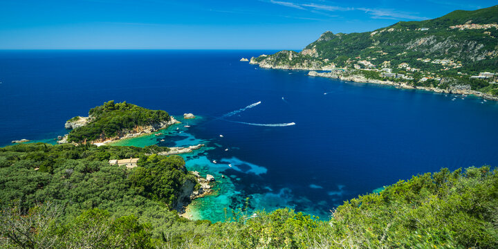 High angle view of small white boats carving wakes in azure waters 