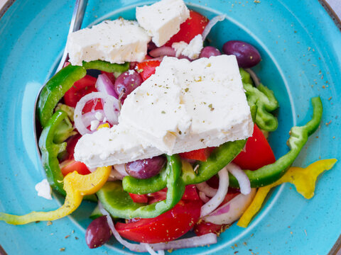 Fresh, colorful Greek salad on blue plate