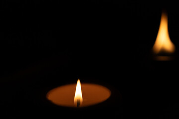 burning candle on black background