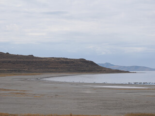 Remote, curving shoreline of the Great Salt Lake against barren hills