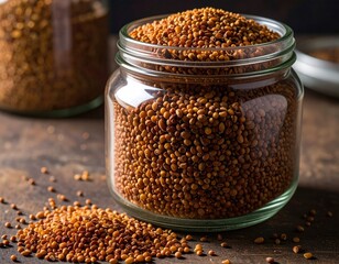 Brown grains in a clear glass jar; pile on table
