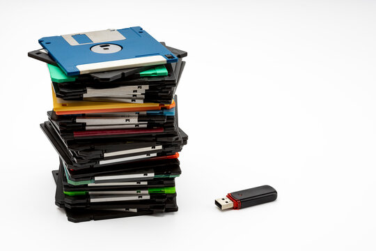 Stack of 3.5" Floppy disk and memory flash drive on white background , Retro digital storage technology