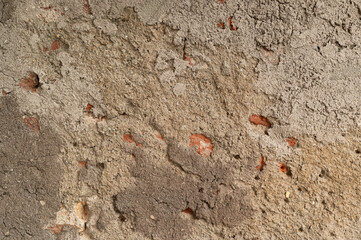 Rough old wall texture with exposed bricks and uneven plaster, suitable as a grunge background or backdrop.