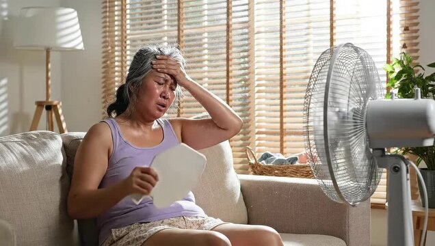Experiencing extreme heatwave at home with a fan during summer season crisis