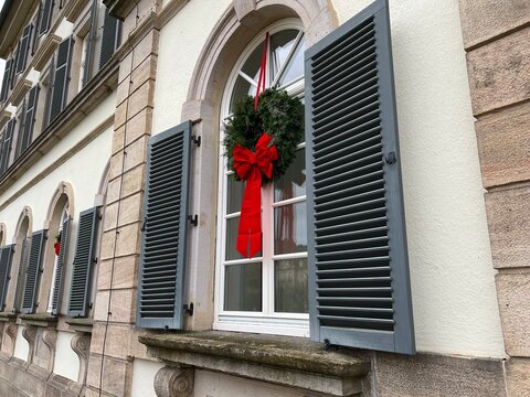 weihnachtliches Sprossen Fenster mit Holzjalousie und gr&uuml;nem Weihnachtskranz