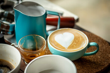 Barista Training Practice Pouring Milk for Latte Art in Workshop Setting, Showing Focused Hand Movement and Technique Pouring Milk into Latte Cup Creating Heart Shaped with Soft Depth of Field.