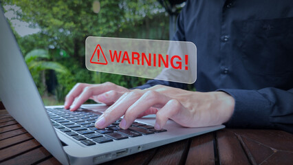 Cybersecurity Warning Overlay on Outdoor Laptop Interface