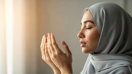 A young Muslim woman in a hijab praying with her hands cupped, seeking blessings and spiritual connection