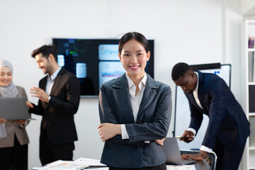 portrait of businesswoman in formal suit standing crossed arms in green office, group of multiracial team colleague diverse employee coworker meeting performance planning