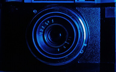 Vintage Camera Lens from the 1960s. Close-up on the aperture ring with engraved numbers against a minimalist blue background. Perfect for photography blogs and tech history articles